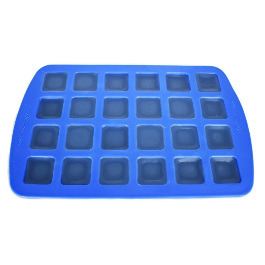 Blue silicone mold with all 24 square cavities filled with cooled dark blue wax